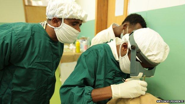 masked surgical staff operating on a patient's eye