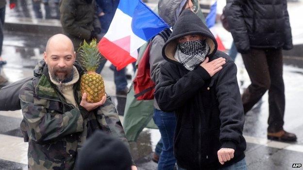 A masked man makes a quenelle gesture in Paris, 26 January