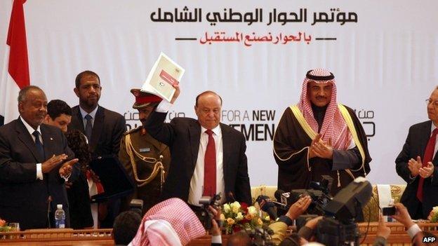 Yemen's President Abdrabbuh Mansour Hadi holds up a copy of the recommendations of the National Dialogue Conference (25 January 2014)