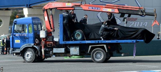 Hamilton's Mercedes is towed back to the garage