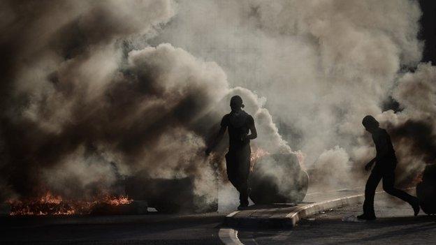 Anti-government protesters clash with riot police after a funeral in western Manama (12 October 2013)