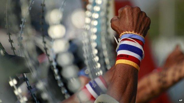 Anti-government protesters chant slogans next to a line of barbed wire during a rally outside the Center for Maintaining Peace and Order (CMPO) on the outskirts of Bangkok, Thailand Wednesday, 29 January 2014