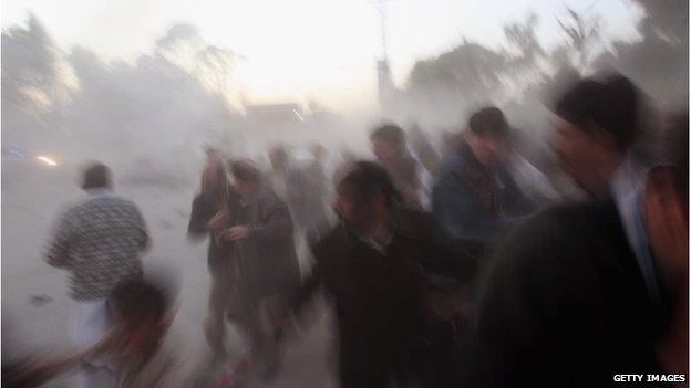 Survivors flee the bomb blast that killed Prime Minister Benazir Bhutto and around 15 others, on 27 December 2007