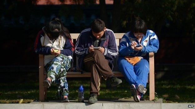 Three people playing on their mobile phones