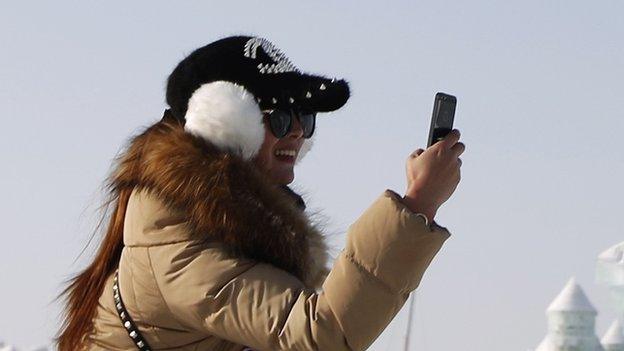 Woman takes picture with mobile phone