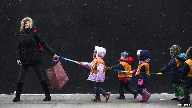 Teacher and pupils catching snowflakes in Harlem