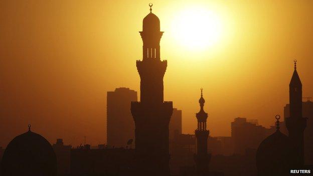 The sun sets over the minarets of mosques on the 12th day of the holy fasting month of Ramadan, in Old Cairo (July 21, 2013)