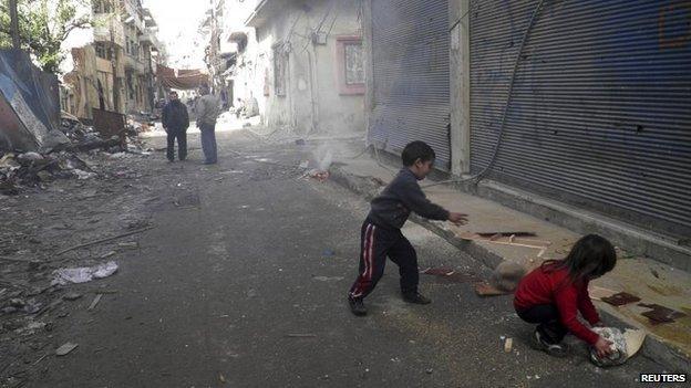 Children cut wood pieces in the besieged area of Homs January 28