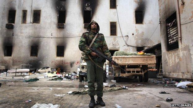 Opposition fighter guards a building in Benghazi (24 Feb 2011)