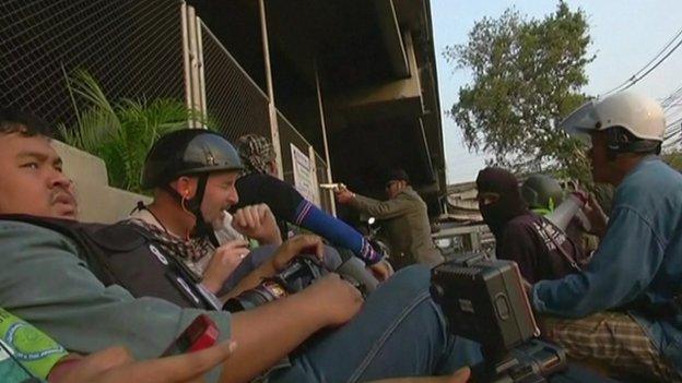 Reporters seek cover while a man fires shots in Bangkok (1 February 2014)