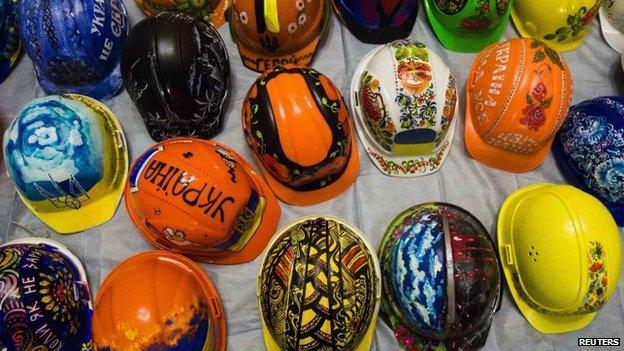 A collection of hardhats painted with motifs for anti-government protesters