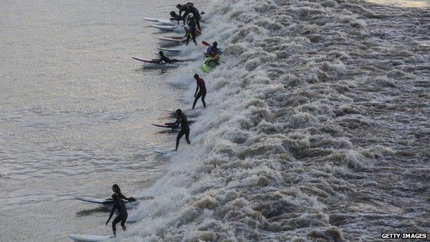 Surfers riding the Severn Bore in Newnham