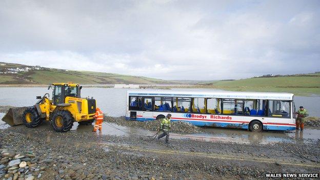 Workers clearing the road by the bus stranded in Newgale