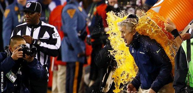 Seattle Seahawks head coach Pete Carroll is given the traditional celebratory soaking by his players after they thrash the Denver Broncos in Super Bowl XLVIII