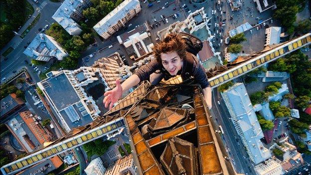 Man clinging to a star at the top of a high-rise building in Moscow.