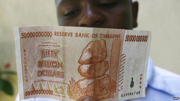 A Zimbabwean looks at a $50bn Zimbabwean issued on 13 January 2009