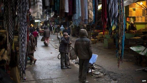 An Afghan boy rests on his wheelbarrow at Mandewi market near the Polle-e-Kheshte mosque in Kabul on January 11, 2014.