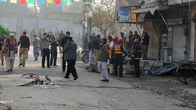 Pakistani security officials inspect the site of a bomb attack in Rawalpindi on 20 January