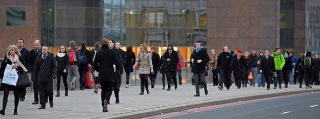 Commuters walk across bridge