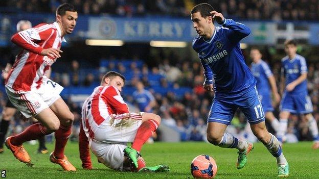 Chelsea's Eden Hazard (right) looks to go around Stoke City's Marko Arnautovic (floor) and Geoff Cameron