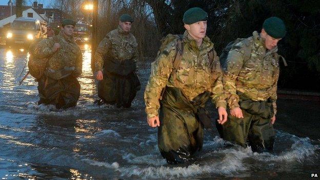 Members of 40 Commando Royal Marines wade through floodwater in Moorland