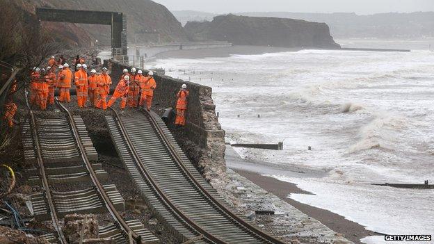 Railway workers inspect the main Exeter to Plymouth railway line that has been closed due to parts of it being washed away by the sea at Dawlish, Devon