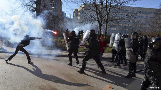 An anti-government protester throws a flare at riot police during clashes in Sarajevo February 7, 2014.