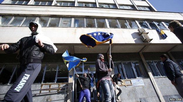 Protesters walk out of a damaged government building in Tuzla February 7, 2014.