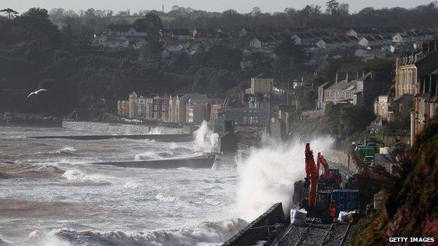 Waves crash over the main Exeter to Plymouth railway line that has been closed due to parts of it being washed away by the sea on February 8, 2014