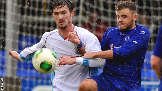 Ballymena's Michael McLellan holds off Dungannon player Fra Brennan