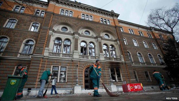 Workers clean up outside a government building in Sarajevo on 8 February 2014