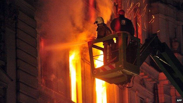 Firefighters try to extinguish fire at a government building in Sarajevo late on 7 February 2014