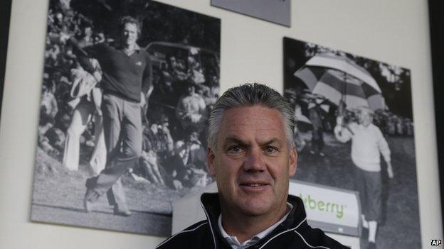 Steve John poses beneath photographs of Clint Eastwood in California