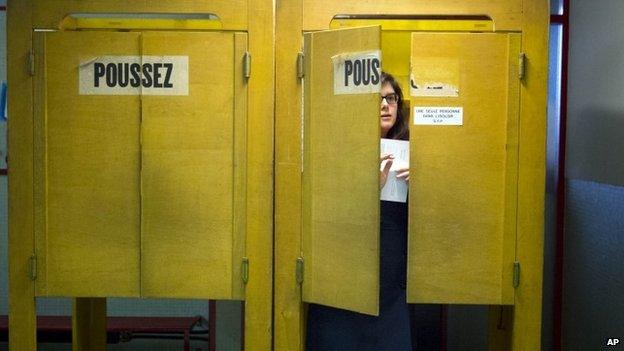 A Swiss voter leaves a polling box at a makeshift polling station