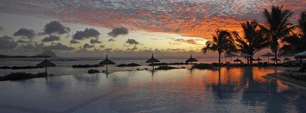 A beach-side swimming pool at sunset