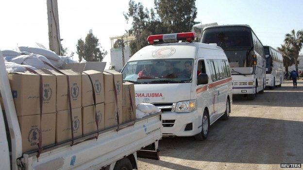 A truck carrying humanitarian aid makes its way to besieged civilians in the old part of Homs