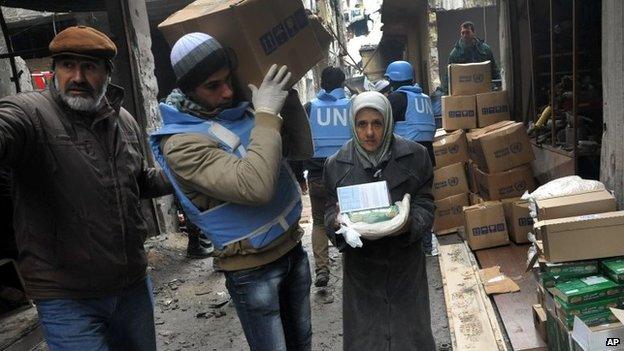 UN relief worker delivers aid inside the Yarmouk refugee camp (4 February 2014)