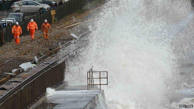 Railway workers are splashed by giant waves that crashed into the coast at Dawlish