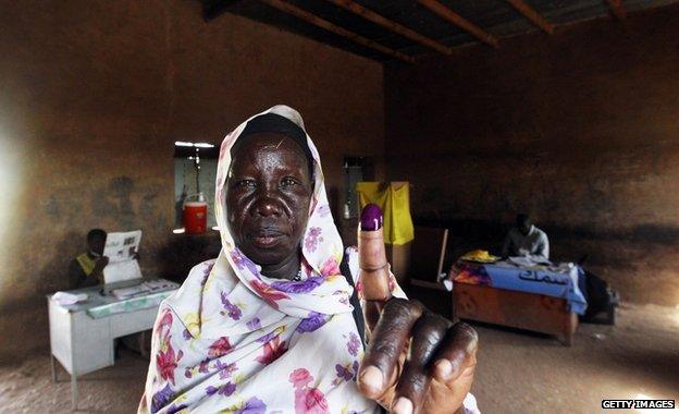 A southern Sudanese woman shows her inked finger after voting at a polling centre in Khartoum