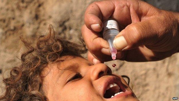 An Afghan healthworker administers a polio vaccination to a child in Herat, Afghanistan, October 2013