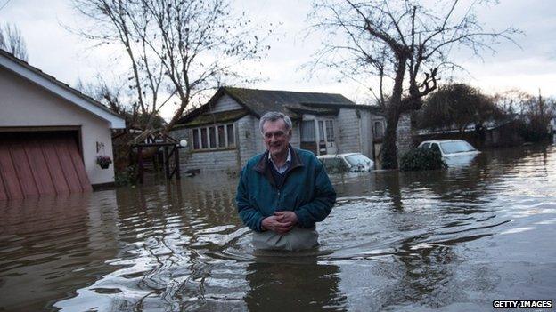 A resident leaves his flood-affected home in Shepperton