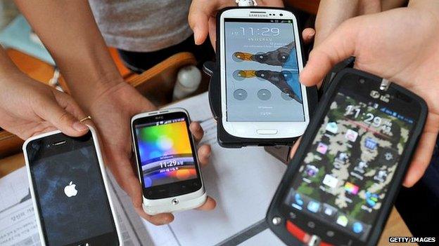 Children holding a selection of smartphones