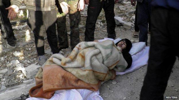 A wounded man is seen on the ground as he waits to be evacuated from a besieged area of Homs 10 February 2014.