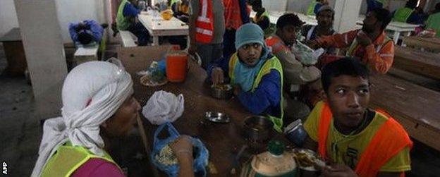 Migrant labourers have a lunch break as they work on a construction site on October 3, 2013 in Doha in Qatar