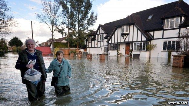 Residents wade through floodwater in the village of Wraysbury in Berkshire