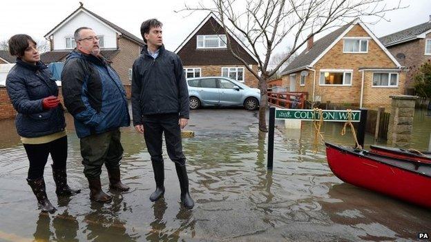 Labour leader Ed Miliband (right) and Victoria Groulef (left), Labour's Parliamentary Candidate for Reading West, with local resident Adrian North (centre) during a visit to the view recent flooding in Purley on Thames in Berkshire.