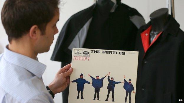 Auctioneer Paul Fairweather with jackets worn by George Harrison (right) and Ringo Starr