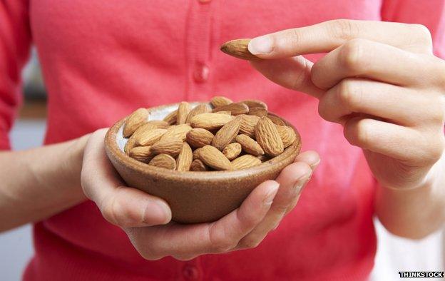 Woman holding bowl of almonds