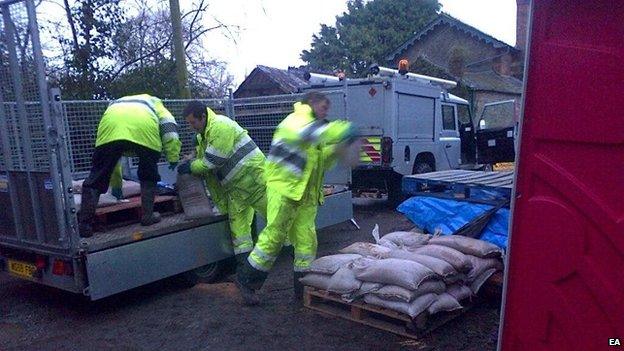 Workers take sandbags to Mordiford where the stream burst its banks