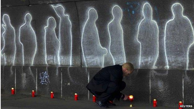 A man lights candles where 21 revellers died, in this 23 July 2011
